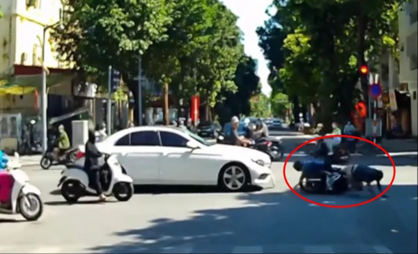 Cặp đôi đi xe máy cố tình vượt đèn đỏ bị ô tô tông trúng