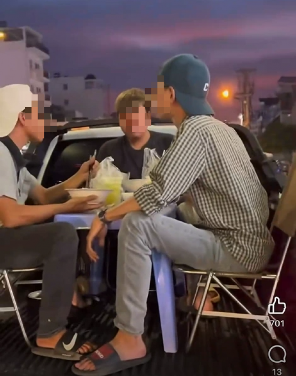 Nhóm người bày bàn ghế, ngồi ăn trên thùng xe bán tải đang chạy ở TP.HCM