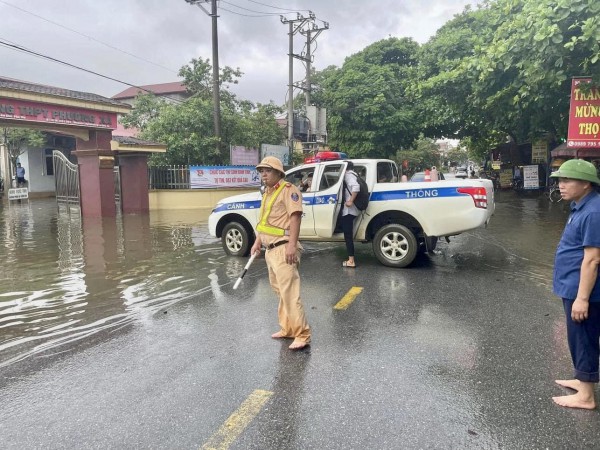 Cổng trường ngập sâu, công an dùng xe chuyên dụng đưa thí sinh vào phòng thi