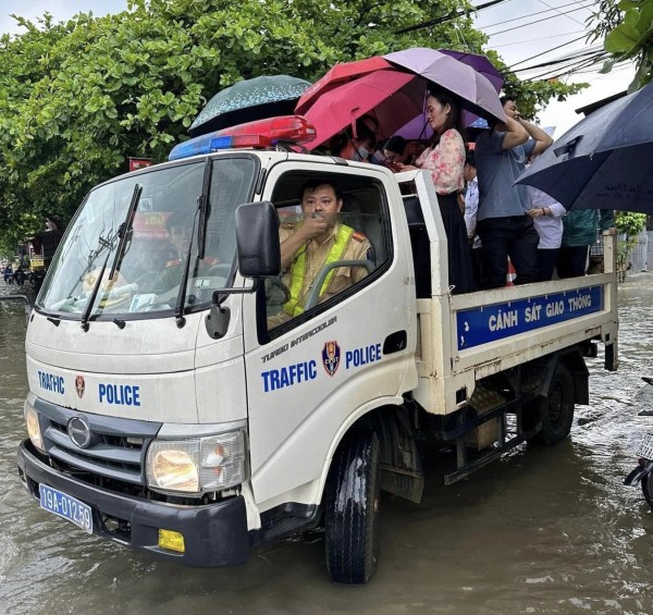 Cổng trường ngập sâu, công an dùng xe chuyên dụng đưa thí sinh vào phòng thi