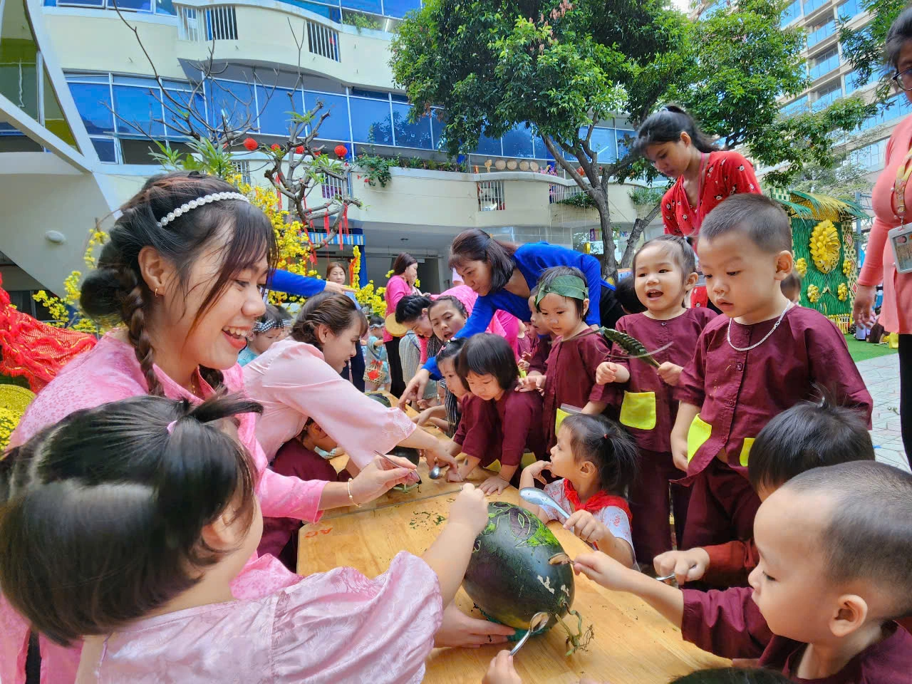 Học sinh chơi đẩy gậy, khắc dưa hấu, làm bánh đón tết ở sân trường