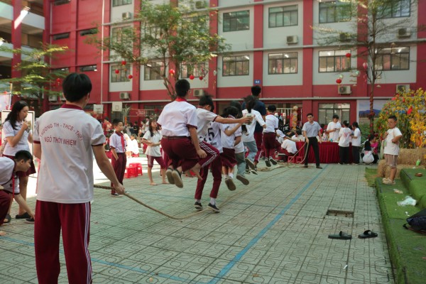 Học sinh chơi đẩy gậy, khắc dưa hấu, làm bánh đón tết ở sân trường