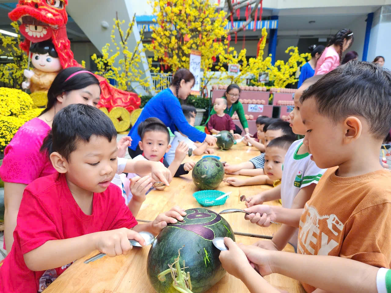 Học sinh chơi đẩy gậy, khắc dưa hấu, làm bánh đón tết ở sân trường