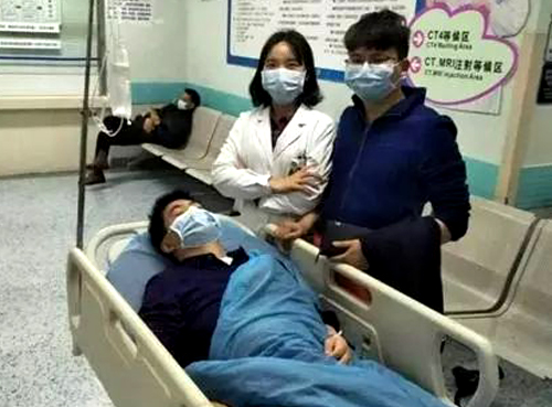 Bác sĩ Tam Ling (mặc áo trắng) chụp ảnh cùng ân nhân 11 năm trước (người đang nằm). Ảnh: Nextshark