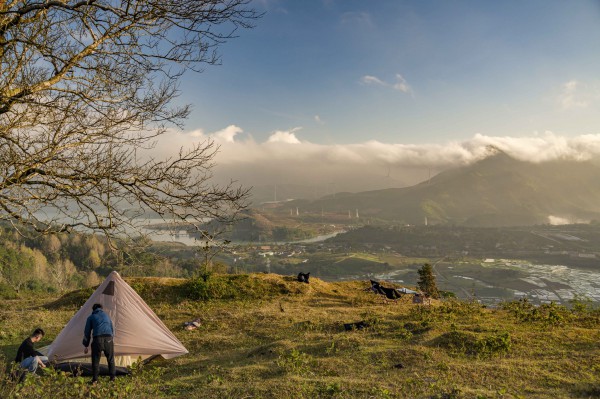 Ngày xuân, cắm trại dưới chân trụ điện gió giữa vùng núi cao
