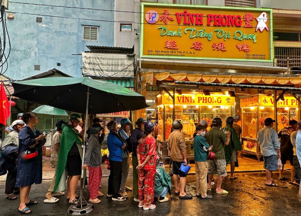 Sáng nay đông nghẹt người ở TP.HCM đội mưa mua vịt quay, heo quay ngày Thần tài