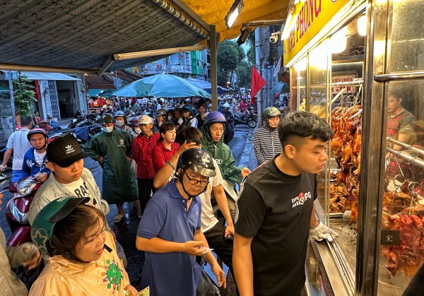 Sáng nay đông nghẹt người ở TP.HCM đội mưa mua vịt quay, heo quay ngày Thần tài