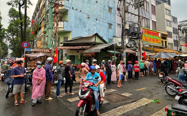 Sáng nay đông nghẹt người ở TP.HCM đội mưa mua vịt quay, heo quay ngày Thần tài
