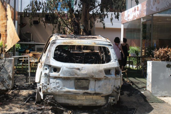 Xe 7 chỗ đậu trong quán cà phê cháy rụi nghi bị ném bom xăng